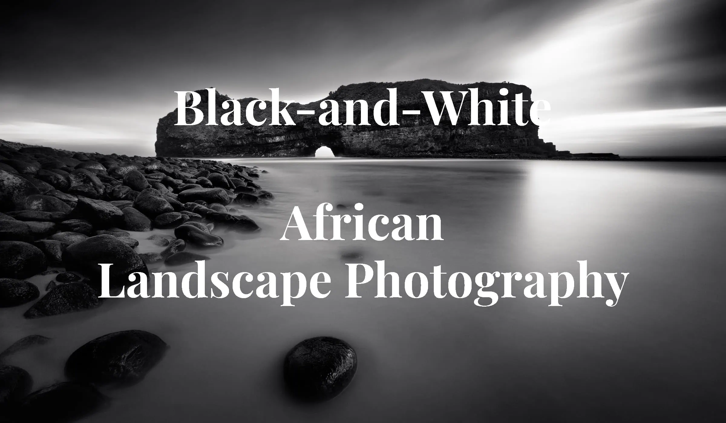 Calm Coast - Hole in the Wall at the Wild Coast of South African with a calm see and rocky beach, in fine art black-and-white African landscape photography by Rudi van den Heever