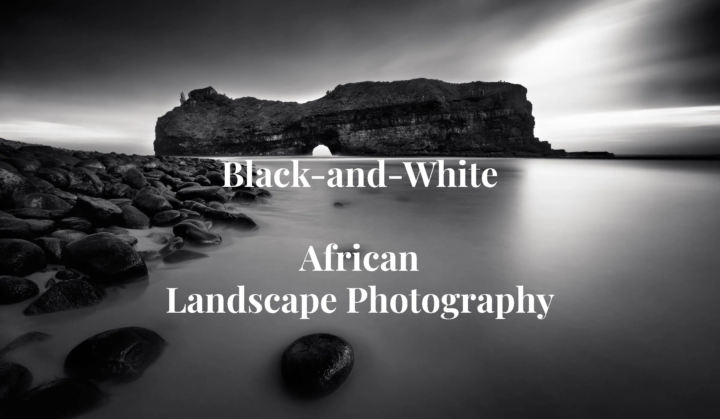 Calm Coast - Hole in the Wall at the Wild Coast of South African with a calm see and rocky beach, in fine art black-and-white African landscape photography by Rudi van den Heever