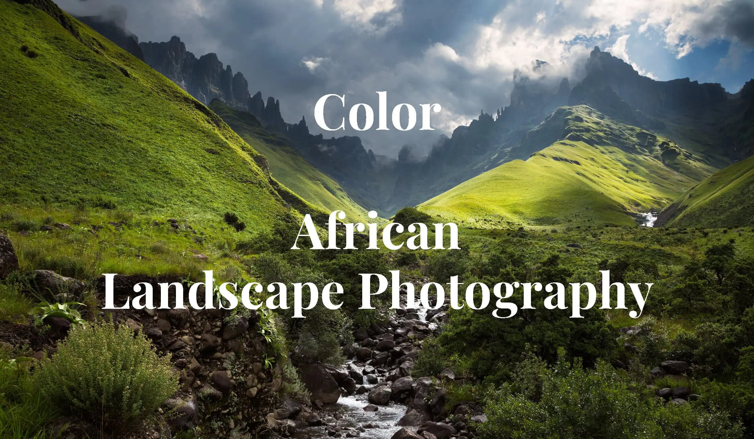 Fangs Valley - Rocky sharp cliffs of Fangs Pass in Drakensberg in background with green grassy slopes and river in foreground, in fine art African landscape photography by Rudi van den Heever